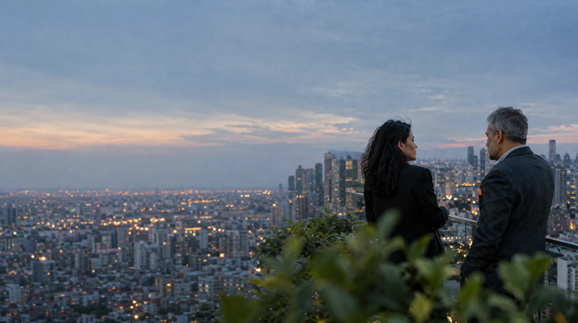 Due partner di profilo su una terrazza all’imbrunire